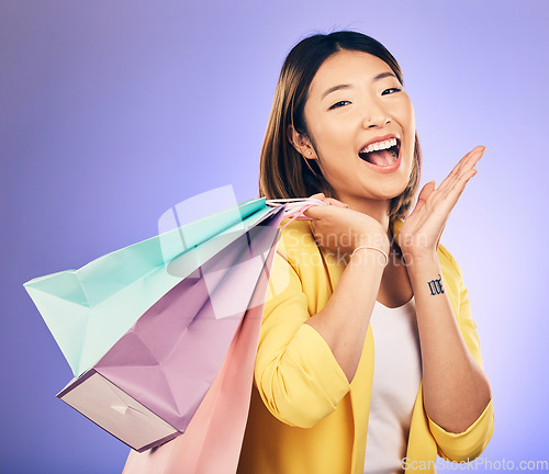 Image of Shopping bag, wow portrait and woman of beauty discount, retail announcement or sale on purple studio background. Cosmetics, excited face and young customer or asian person for prize, gift or winning