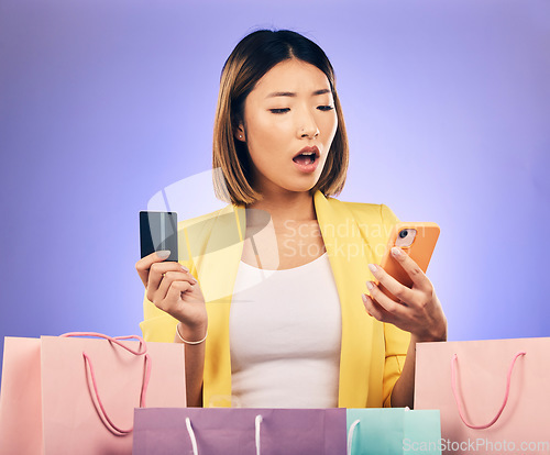 Image of Credit card, phone and woman stress, surprise or shocked for online shopping scam, news or fintech payment problem. Wow, retail bag and asian person for e commerce mistake on purple studio background