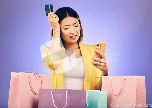 Image of Woman, confused and credit card, phone and online shopping scam, news or fintech payment problem. Stress, retail bag and sad asian person in e commerce mistake on mobile and purple studio background