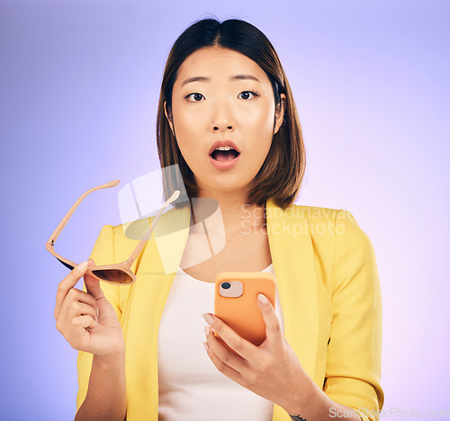 Image of Phone, asian and portrait of woman surprise for online shopping discount, fashion deal or cellphone announcement. Smartphone notification, studio update or face of shocked person on purple background