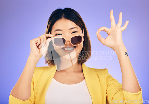 Image of Happy asian woman, portrait and sunglasses, OK sign or fashion accessory against a purple studio background. Female person or model smile with okay gesture in satisfaction for perfect summer style