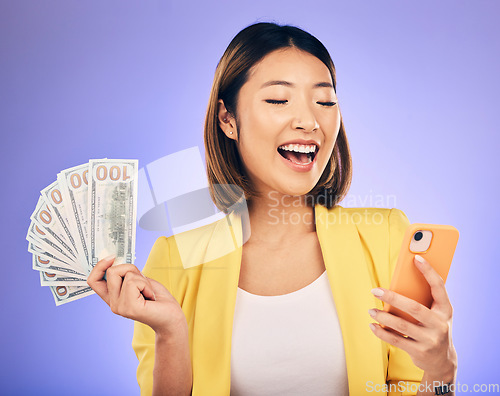 Image of Cash, phone and happy woman for winning finance, online savings or fintech profit and cashback. Success, lottery and winner or asian person on mobile, money fan or banking on studio purple background