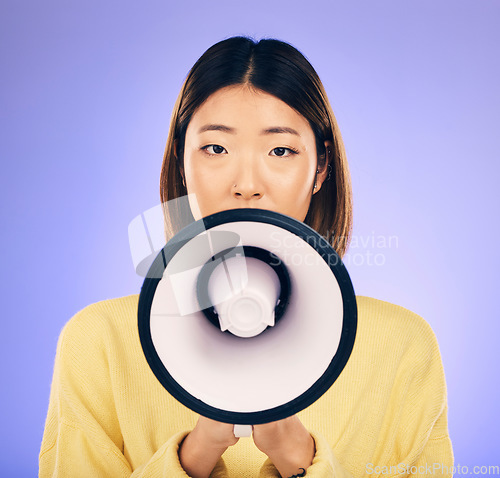 Image of Woman, megaphone and portrait in studio for announcement, voice or broadcast. Face of a young asian female speaker with a loudspeaker for communication, sad message or speech on purple background