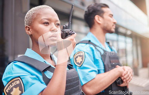 Image of Police, radio and patrol with a black woman officer outdoor on a city street for law enforcement. Walkie talkie, communication and a female security guard talking during crime prevention for safety