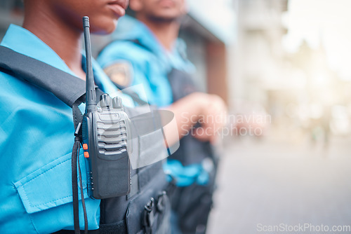 Image of Radio, police and surveillance with a black woman officer standing outside while on patrol in the city. Walkie talkie, dispatch or communication with a female security guard in an urban town