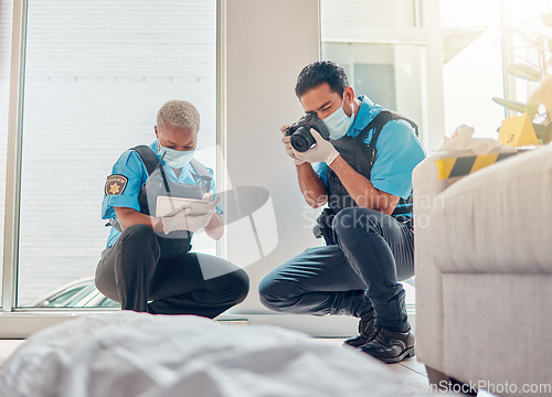 Image of People, police and investigation at the crime scene for murder, victim or case of death at home. CSI man and woman writing notes, pictures or photography for law enforcement or evidence in the house