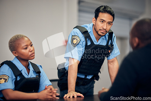 Image of Interrogation, arrest and police team with a suspect for questions as law enforcement officers. Security, crime or investigation with a serious man and woman cop talking to a witness for information