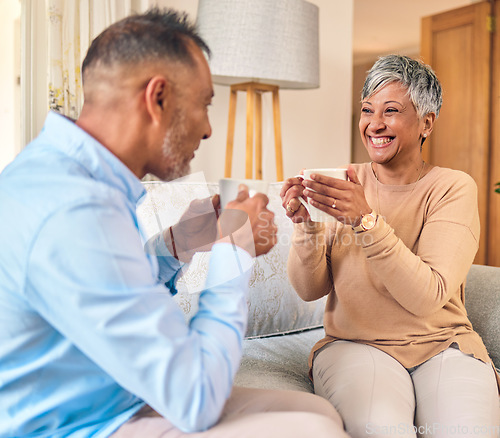 Image of Coffee, retirement and a senior couple on a sofa in the home living room to relax while bonding in conversation. Smile, love or marriage with a mature man and woman talking while drinking a beverage