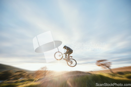 Image of Fitness, cycling and person with bicycle jump for extreme sports and energy on blur mockup space . Action, bike and cyclist athlete in the countryside with speed, trick and skill, adventure or power