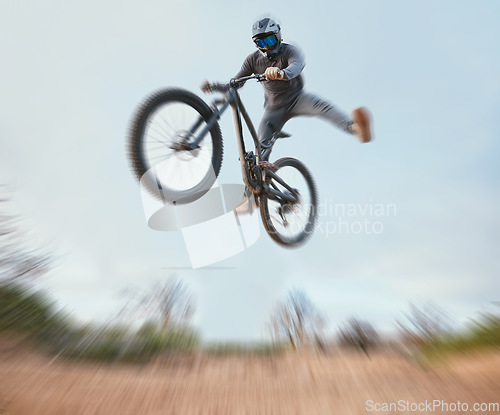 Image of Mountain, bicycle jump and athlete cycling on a bike for extreme sports competition stunt or training in nature. Skill, contest and person workout or action on sky or air trick for fitness with blur