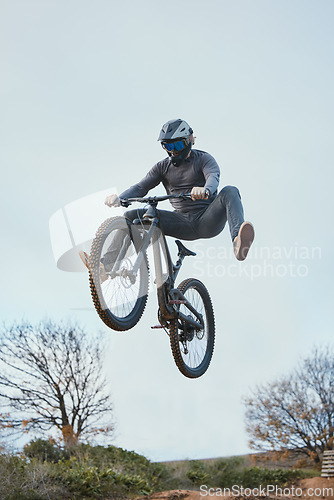 Image of Mountain, bike jump and person cycling on bicycle for extreme sports competition stunt or training in nature. Skill, contest and professional athlete workout or action on sky or air trick for fitness