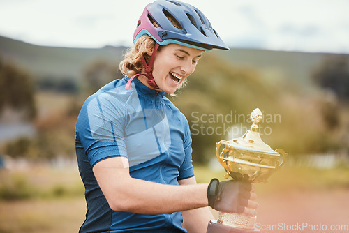 Image of Winner, trophy and achievement with a woman cyclist in celebration of victory outdoor after a race. Award, motivation and success with a happy young female athlete winning a cycling competition