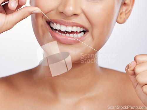 Image of Mouth, face and woman floss teeth for dental health, care or gingivitis on studio background. Closeup of female model, oral thread and cleaning string for fresh breath, tooth hygiene or healthy habit