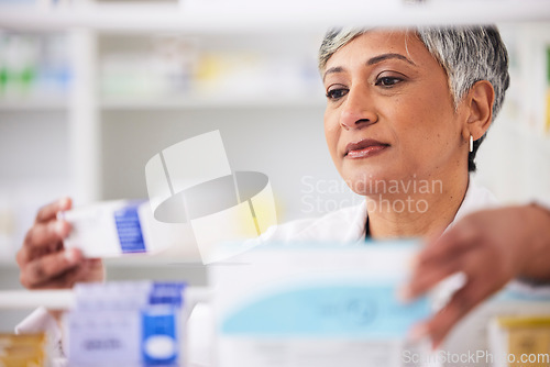 Image of Pharmacist, shelf and a woman with a medicine box in a pharmacy for inventory or prescription. Mature female employee in healthcare, pharmaceutical and medical industry reading product information