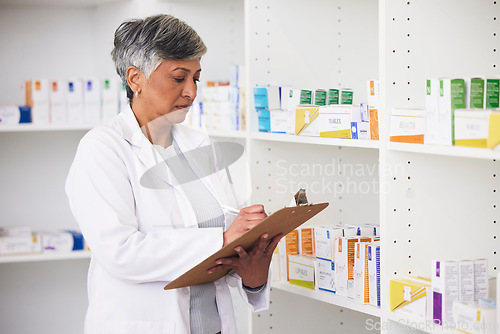 Image of Pharmacist, medicine and a woman writing on a clipboard in a pharmacy for inventory or checklist. Mature female employee check shelf for management in healthcare, pharmaceutical and medical industry