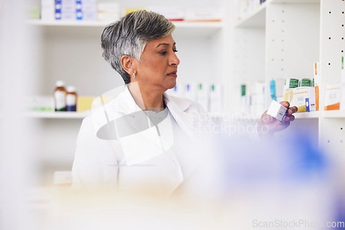 Image of Pharmacist, shelf and a woman reading a medicine box label in a pharmacy for knowledge. Mature female employee in healthcare, pharmaceutical and medical industry to check product information on stock