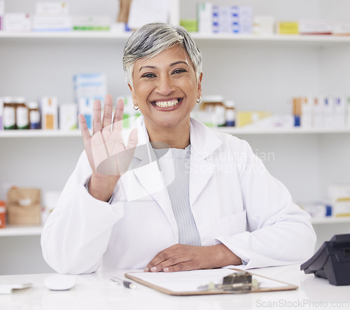 Image of Pharmacist, portrait and hand of woman for hello at pharmacy counter for friendly service with a smile. Mature female employee in healthcare, pharmaceutical and medical industry for medicine retail