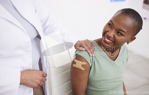 Image of Doctor, patient and plaster on arm for vaccine, medicine and protection for virus with happy black woman in clinic. Medic, african girl and smile for helping hand, injection and strong immune system