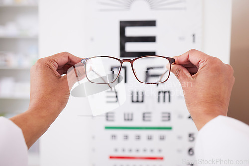 Image of Glasses in hands, optometry and vision, eye care and health with eyesight test and chart, prescription lens and frame. Ophthalmology, focus and healthcare, person in optometrist clinic and eyewear