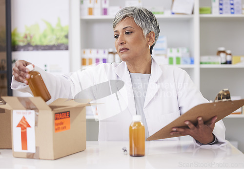 Image of Woman, doctor and box at pharmacy for inventory inspection, logistics or delivery at drug store. Senior female person, medical or healthcare professional checking pharmaceutical stock or medication