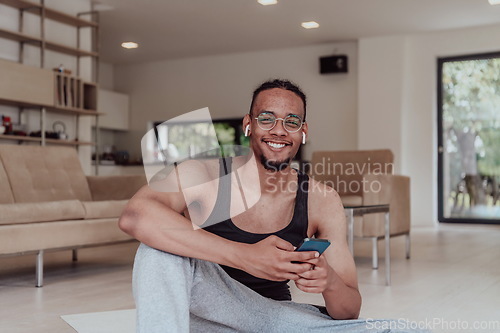 Image of Training At Home. Sporty man doing training while watching online tutorial on laptop, exercising in living room, free space.