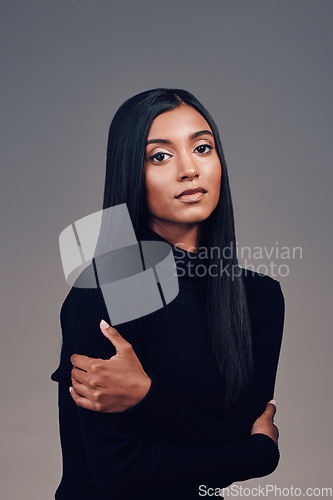 Image of Indian, woman with beauty and portrait with arms crossed, confidence and mindset with focus, vision or motivation in studio. Serious, calm face and model thinking of idea for fashion on background