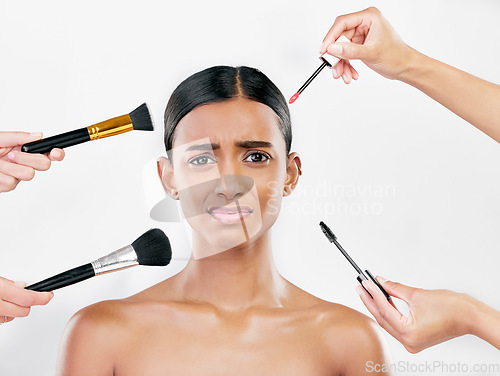 Image of Makeup, brush and anxiety, woman with beauty shine and overwhelmed with beautician on white background. Doubt with cosmetics, tools and hands crowd female model in studio, cosmetology and skin glow