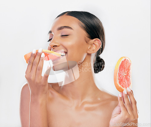 Image of Eating, grapefruit and Indian woman with natural beauty, skincare and cosmetics for healthy glow, citrus or vitamin c. Face, skin care and eat fruit for wellness, health of body and white background