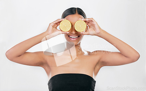 Image of Indian woman, portrait with lemon for beauty, skincare and natural cosmetics for healthy glow, citrus or vitamin c. Face, eyes and skin care with fruit for wellness, health and white background