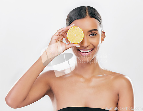 Image of Happy, lemon and portrait of a woman for skincare, beauty glow or vitamin c for health. Smile, wellness and an Indian model or girl with fruit for diet isolated on a white background in a studio