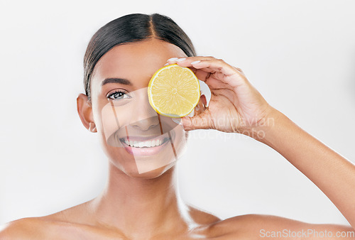 Image of Happy, lemon and portrait of a woman for nutrition, beauty glow or vitamin c for skincare. Smile, wellness and an Indian model or girl with fruit for diet isolated on a white background in a studio