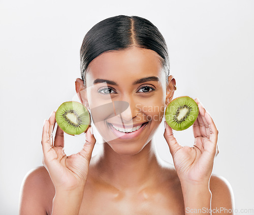 Image of Skincare, health and portrait of a woman with kiwi for nutrition, diet and wellness. Happy, spa treatment and an Indian girl or model with fruit or food for facial isolated on a white background