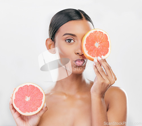Image of Indian woman, portrait with grapefruit for beauty, skincare and natural cosmetics for healthy glow, citrus or vitamin c. Face, emoji and skin care with fruit for wellness, health and white background