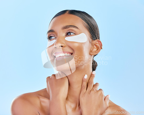 Image of Eye patch, face and beauty of a happy woman with natural skin glow on a blue background. Dermatology, collagen mask and cosmetics of Indian person for facial shine, wellness or self care in studio