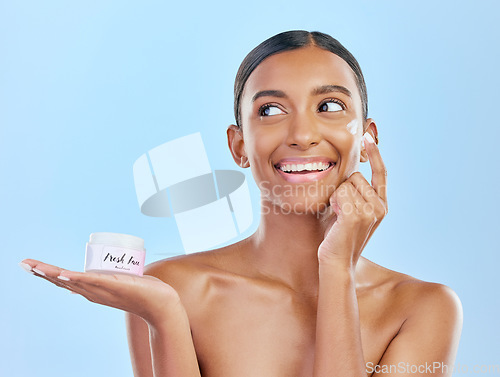 Image of Face, cream in hand and beauty, woman with skincare and cosmetics product isolated on blue background. Lotion, sunscreen and facial mask, smile and moisturizer with female model and dermatology