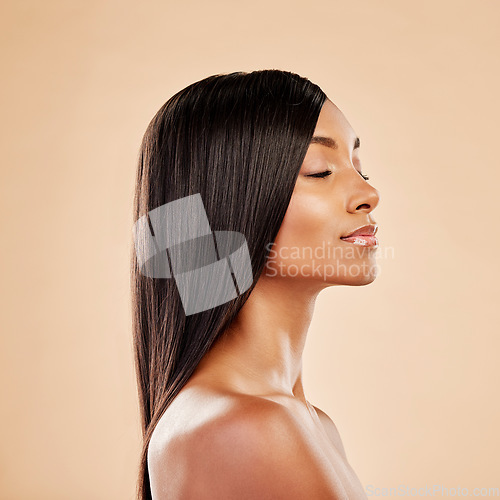 Image of Beauty, hair care and profile of a woman in studio with natural glow and shine. Hairstyle, cosmetics and wellness of Indian person for hairdresser, makeup or salon results on a beige background