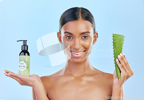 Image of Woman, aloe vera and skincare in studio portrait with smile, natural choice and happy by blue background. Girl, model and cactus plant for health, wellness and bottle with serum, care and facial glow