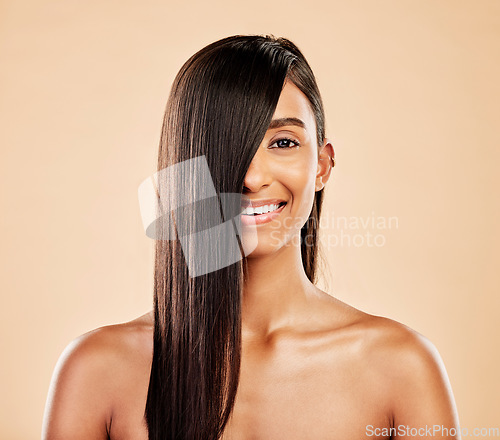 Image of Hair care, smile and portrait of a woman on a studio background with salon treatment. Beauty, happy and headshot of an Indian model or girl showing healthy shampoo results isolated on a backdrop