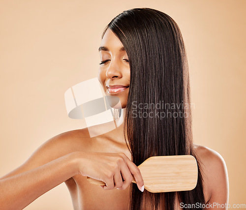 Image of Face, hair beauty and brush with a woman in studio on a cream background for natural or luxury style. Haircare, growth and shampoo treatment with a young indian female model eyes closed at a salon