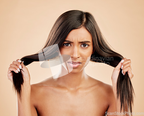 Image of Hair, damage and portrait of woman in stress on studio background for dry texture, aesthetic beauty and cosmetics problem. Face, frustrated indian female model or anxiety for hairstyle with split end