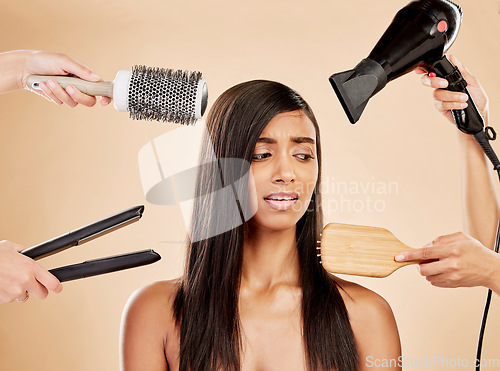 Image of Hair, electric tools and damage of woman for beauty, heat treatment and stress on studio background. Indian female model, worry and anxiety for aesthetic equipment of brush, hairdryer and flat iron