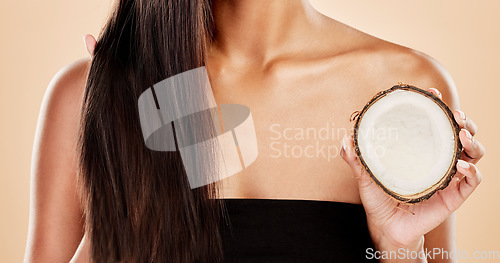 Image of Closeup, woman or coconut of hair, beauty or cosmetic treatment for natural growth, sustainable cosmetics or studio background. Female model, tropical fruits or vegan dermatology of healthy hairstyle