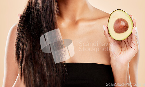 Image of Closeup, woman and avocado for hair, beauty or cosmetic treatment for natural growth, shampoo cosmetics or studio background. Female model, green fruits or vegan dermatology of healthy hairstyle care