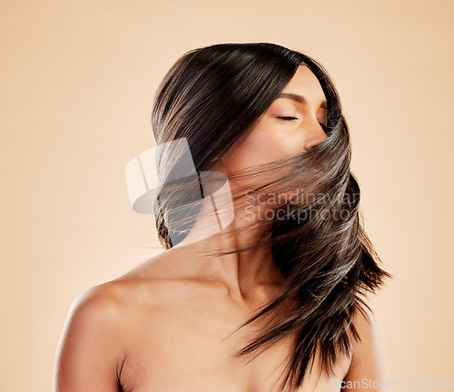 Image of Woman, beauty and shake hair in studio for aesthetic shine, volume and smooth shampoo results. Indian female model, salon treatment and wind in hairstyle for growth, soft texture and cosmetic care