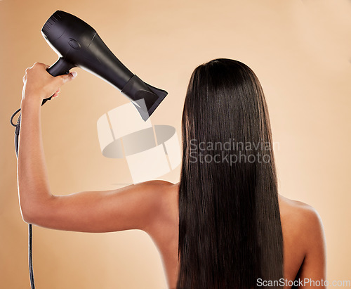 Image of Hair, beauty and back view, woman with hairdryer and keratin treatment with heat on studio background. Female model, cosmetics and haircare with salon hairstyle, equipment and blow dry with shine