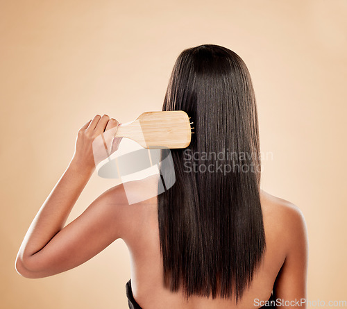 Image of Back of woman, brush and hair care in studio, background and grooming of smooth texture. Beauty, growth shampoo and female model with comb tools for aesthetic hairstyle, keratin treatment and shine