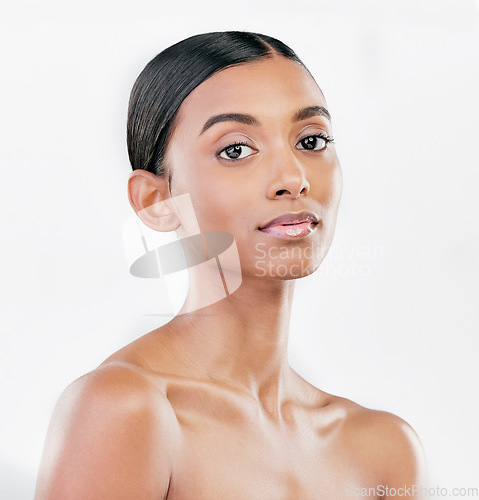 Image of Beauty, face and portrait a woman with natural skin care on a blue background with cosmetics. Dermatology, makeup glow and Indian female model for facial shine, wellness and self love in studio