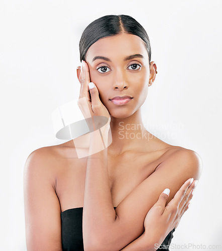 Image of Beauty, hand on face and portrait a Indian woman with natural skincare isolated on a white background. Dermatology, makeup glow and cosmetics with female model for facial shine or self care in studio