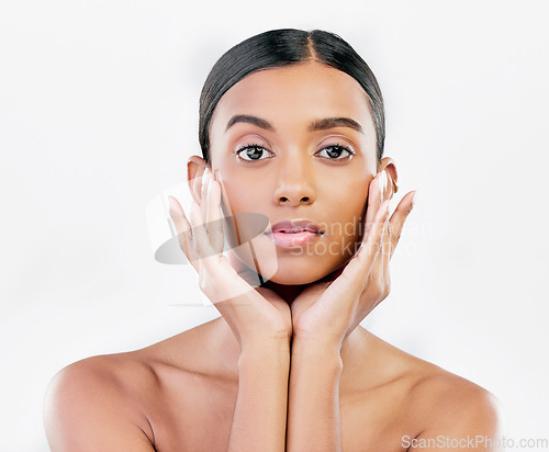 Image of Beauty, portrait and a woman with hands on face for natural skincare isolated on a white background. Dermatology, makeup glow and cosmetics with a serious Indian person for facial shine and self care