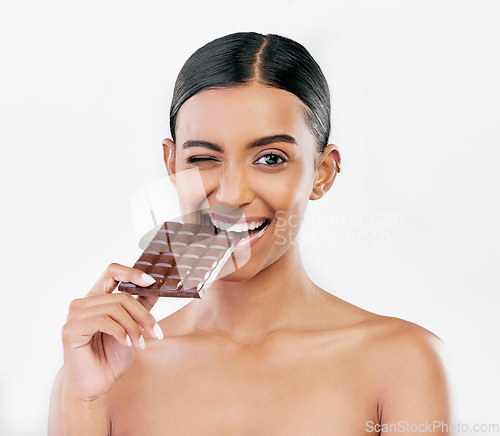 Image of Happy woman, chocolate and candy bite for diet or unhealthy eating against a white studio background. Portrait of female person or model with cocoa slab, block or bar for snack or diabetes on mockup